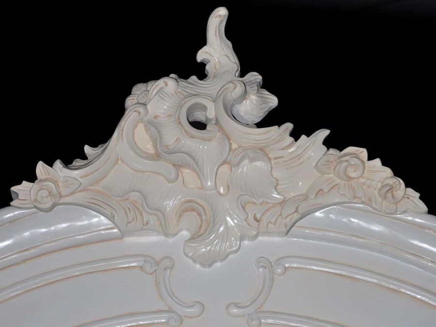 Front view, the cabriole legs and convex top center of the center mirrored doors.