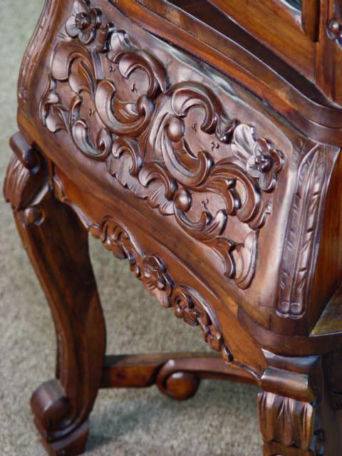 Wood carving detail on the vitrine base section