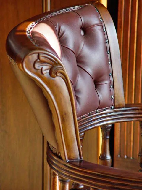 Leaf carving detail on backrest frame of Victorian swiveled chair