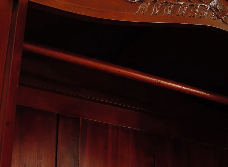 Wooden hanger inside the compartment of the French classic bonnet top armoire 