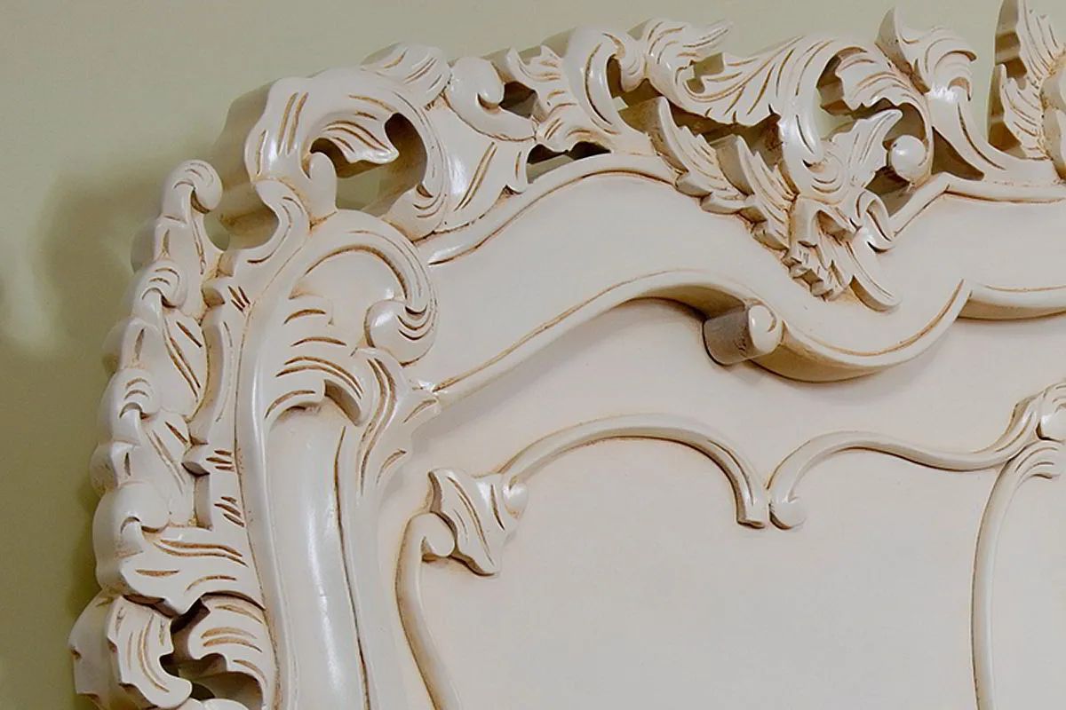Headboard carving detail of white painted rococo bed