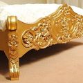 Wood carving detail of gold painted rococo bed