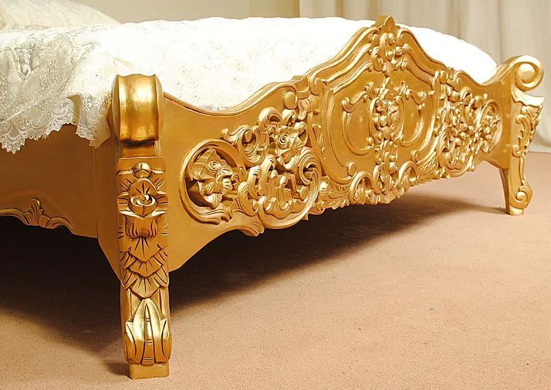 Wood carving detail of gold painted rococo bed