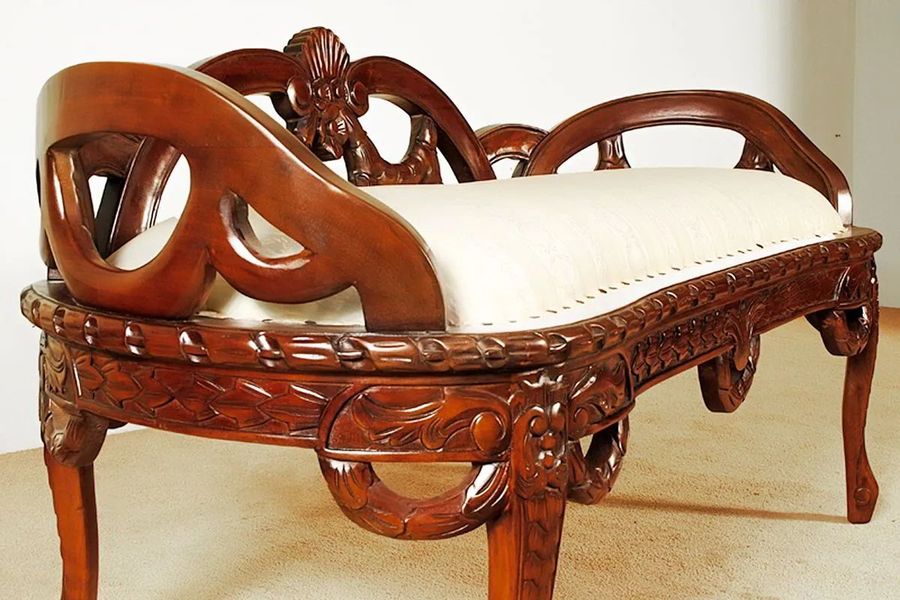 Ribbon carving and flower accent detail on the seat and legs of Rococo bedroom bench