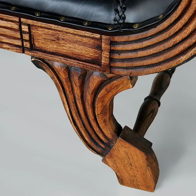 Leg and stretcher detail of the Teak leather loveseat